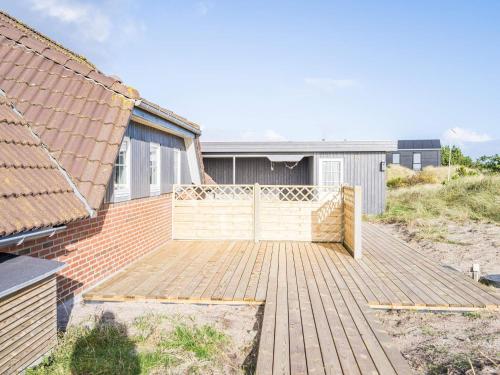 a wooden deck in front of a house at 6 person holiday home in Hvide Sande in Bjerregård