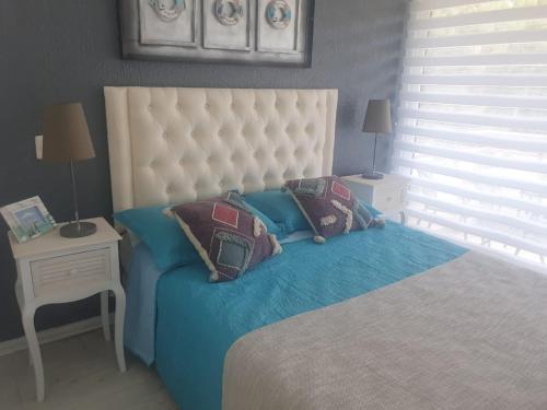 a bedroom with a bed with a white headboard and pillows at Departamento en Reñaca ARRIENDO in Viña del Mar