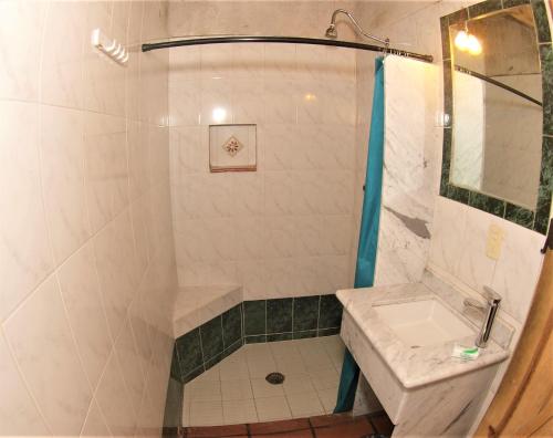 a bathroom with a shower and a sink at Hotel Cabaña Los Ruiseñores in Mazamitla