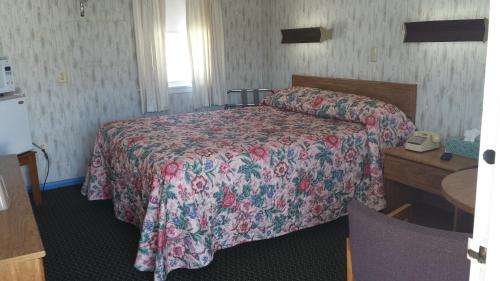 a hotel room with a bed and a telephone at Sunset Inn in Lee