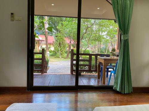 a room with a door open to a patio with a table at Kaibae Hut Resort in Ko Chang