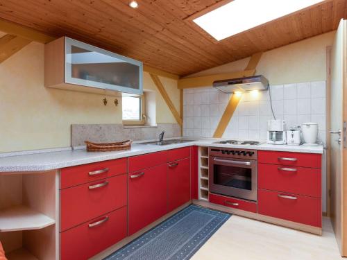 a red kitchen with a sink and a stove at Vacation apartment in Usedom on the Baltic Sea in Stolpe auf Usedom