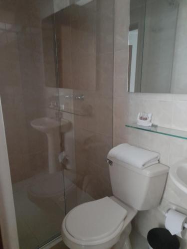 a bathroom with a toilet and a glass shower at Hotel Confort Bogota in Bogotá