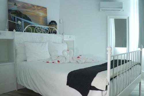 a bedroom with a white bed with white pillows at Trisara - Las Playitas in Las Playas