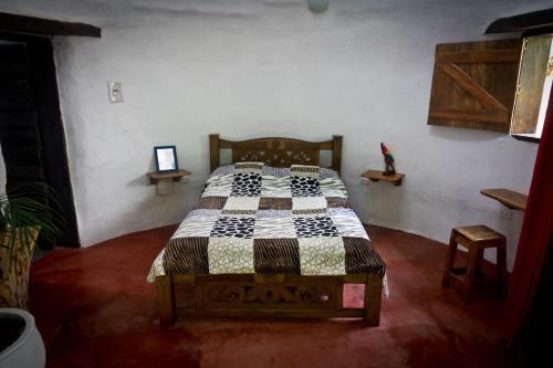 ein Schlafzimmer mit einem Bett mit einer karierten Decke darauf in der Unterkunft Domo 1 en la selva a 3 km de Minca in Minca