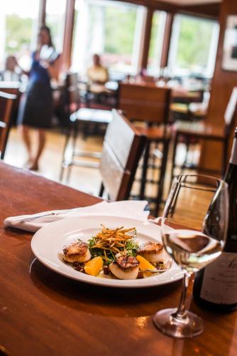 a plate of food on a table with a glass of wine at Black Point Inn in Scarborough