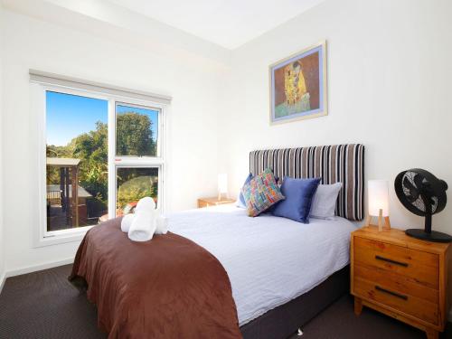 a bedroom with a bed with a stuffed animal on it at The Wharf House at Budgewoi in Budgewoi