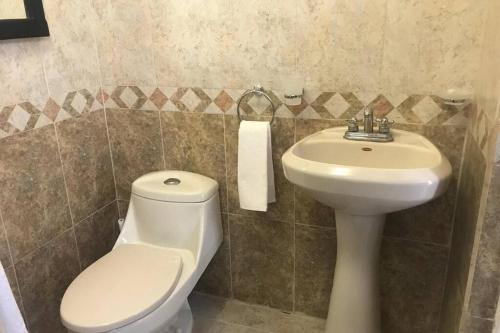 y baño con aseo y lavamanos. en Departamento Del Mar, un lugar cómodo y agradable., en La Paz