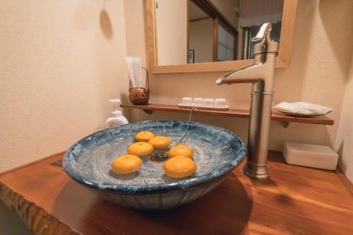 een wastafel met sinaasappels in een kom bij Guesthouse Chayama in Kyoto