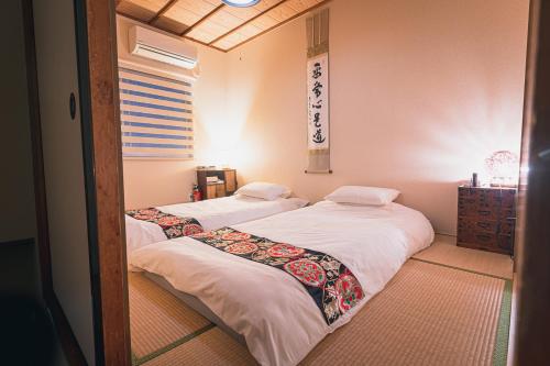two beds in a room with a mirror at Guesthouse Chayama in Kyoto