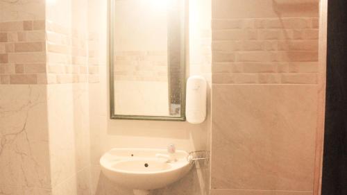 a bathroom with a sink and a mirror at nDalem Joglo Krawitan Syariah in Yogyakarta