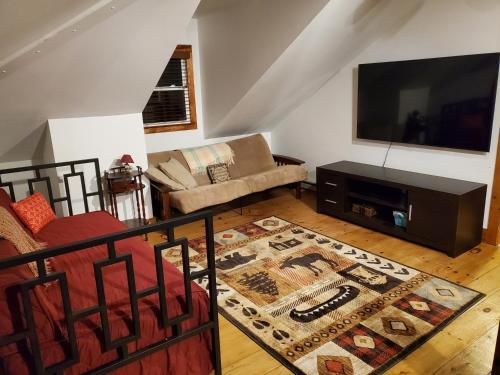 a living room with a couch and a television at Brown's Beach at Schroon Lake in Schroon Lake