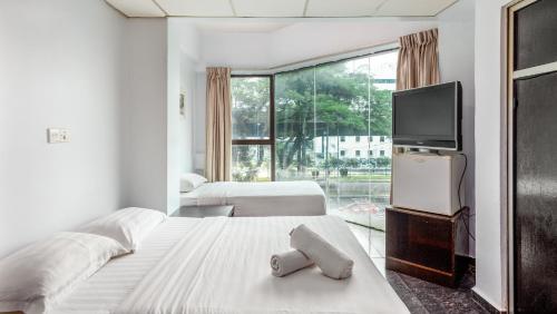 a bedroom with two beds and a flat screen tv at Subang Valley in Subang Jaya