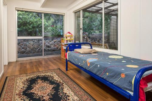 a bedroom with a bed and a large window at Eagle Bay Beach House in Dunsborough