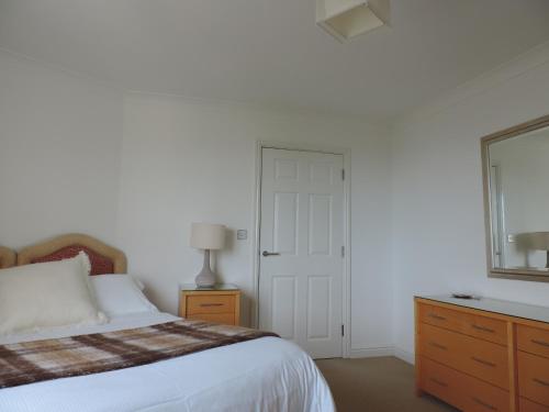 una camera da letto con un letto, un comò e una finestra di Sea Breeze Apartment a St Austell