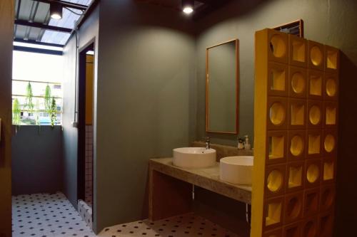 a bathroom with two sinks and a mirror at Bangpho Story in Bangkok