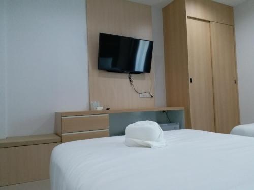 a hotel room with a bed and a flat screen tv at Areena Hotel Phitsanulok in Phitsanulok