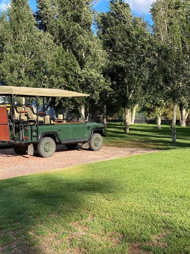 a green jeep with a yellow roof parked in a park at Big Sky Ranch in Colesberg