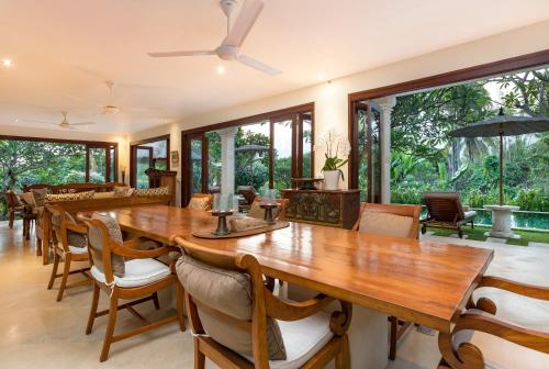 a dining room with a large wooden table and chairs at Villa Perle an Idyllic Luxury Retreat in Karangasem