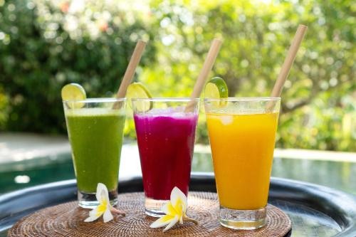 three colorful juices in glasses on a tray at Villa Perle an Idyllic Luxury Retreat in Karangasem