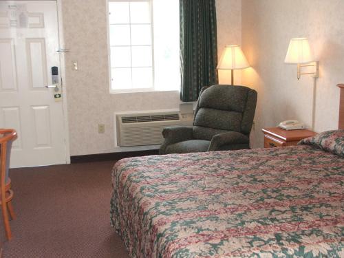 Pokój hotelowy z łóżkiem, krzesłem i oknem w obiekcie Deerfield Inn & Suites w mieście Greenbrier