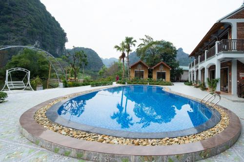 a large swimming pool in front of a building at HoangLong Riverside Homestay in Ninh Binh