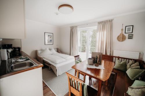 eine Küche und ein Wohnzimmer mit einem Tisch und einem Sofa in der Unterkunft EnjoyTheAlps - Appartements BARBARA in Flachau
