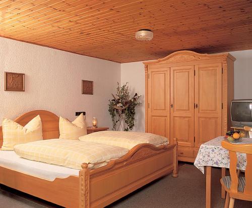 リントベルクにあるZur Alten Dampfsäge - Gasthaus-Pension Weberのベッドルーム(木製ベッド1台、テレビ付)