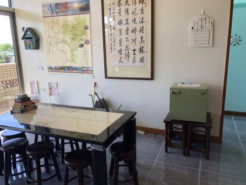 a room with a table and stools and a refrigerator at 悟 佐茶 Satori tea in Leye