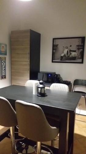 una habitación con una mesa con sillas y una foto en Villa Vittorio, en Infernetto