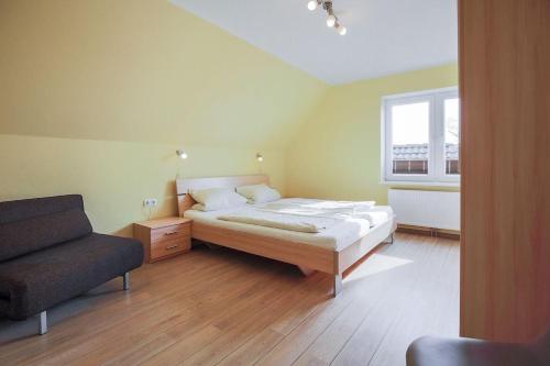 - une chambre avec un lit, un canapé et une fenêtre dans l'établissement Buedlfarm-Grosse-Wohnung, à Sahrensdorf