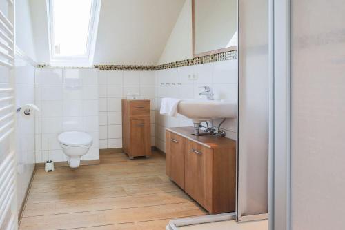 La salle de bains est pourvue d'un lavabo et de toilettes. dans l'établissement Buedlfarm-Grosse-Wohnung, à Sahrensdorf