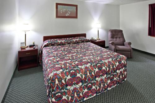 キャデラックにあるCadillac Innのベッドと椅子付きのホテルルーム