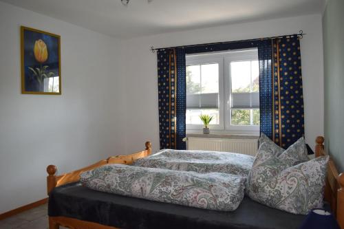 a bedroom with a bed with a window and a bedspread at Haus-am-Dorfteich-Kopendorf-Wohnung-2 in Kopendorf