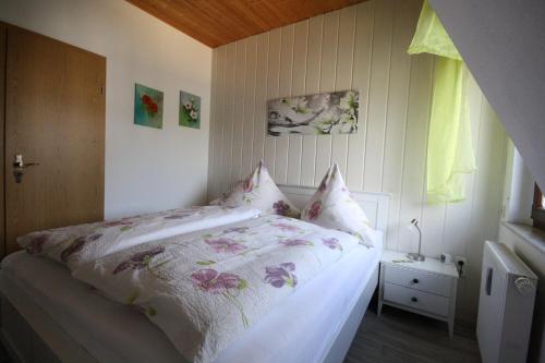 1 Schlafzimmer mit einem Bett mit Blumenbettdecke in der Unterkunft Kleine Fewo Ebert&Green in Neudorf