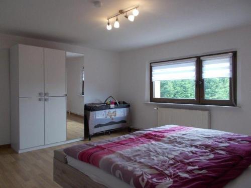a bedroom with a large bed and a window at Janos-Ferienwohnung-2 in Friedrichsbrunn