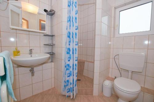 ein Bad mit einem WC, einem Waschbecken und einem Fenster in der Unterkunft Ferienwohnung am Berg (2 Erw. & 2 Kinder bis14 Jahre) in Groß Banzelvitz
