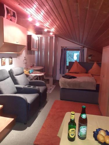 a living room with a bed and two bottles on a table at Landhaus-Königsberg, Vorberg 360 Ebengütlweg in Ramsau am Dachstein