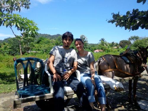 a man and a woman sitting on a horse drawn cart at Acuali EcoHostal in Capurganá