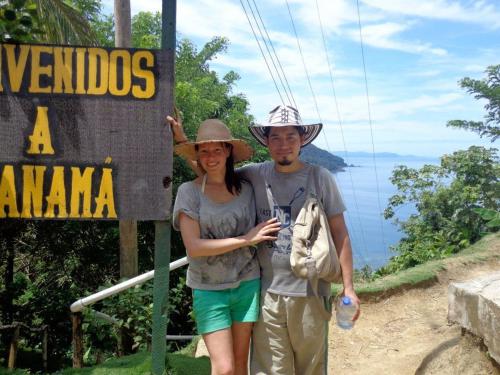 a man and a woman standing in front of a sign at Acuali EcoHostal in Capurganá