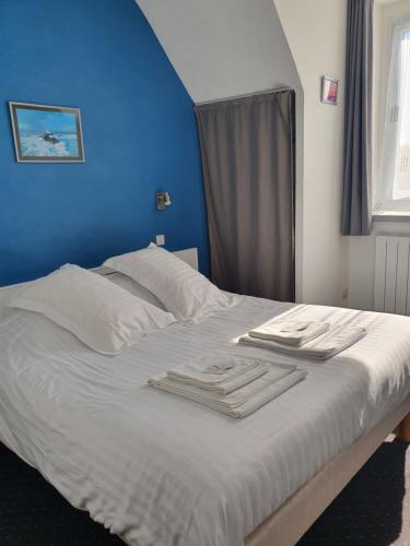 ein Bett mit weißer Bettwäsche und Handtüchern darauf in der Unterkunft Hôtel Glann Ar Mor in Arzon
