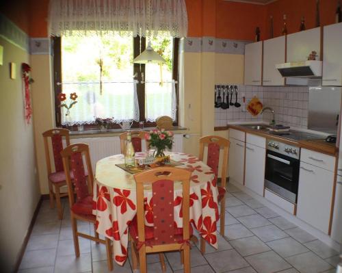 eine Küche mit einem Tisch, Stühlen und einer Tischdecke in der Unterkunft  Ferienwohnung im Teutoburger Wald in Schieder-Schwalenberg
