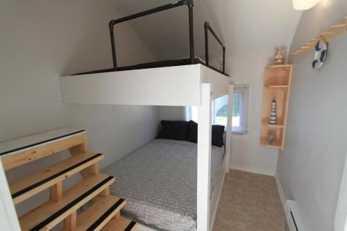 a small bedroom with a bunk bed in a house at Plovers Cove Cottage in Wasaga Beach