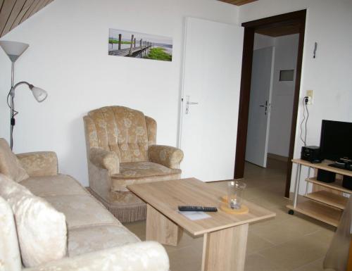 uma sala de estar com um sofá e uma mesa de centro em Goldene-Linie-4-Taubennest em Wangerland