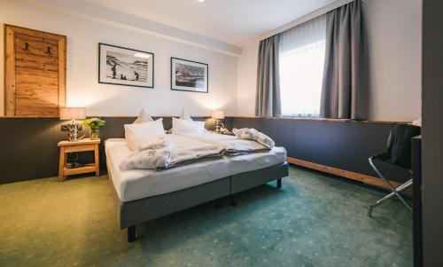 
a hotel room with a bed and a desk at Arlen Lodge Hotel in Sankt Anton am Arlberg
