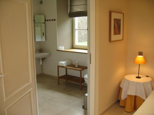 łazienka z toaletą, stołem i oknem w obiekcie Domaine des Grattières w mieście Hermonville
