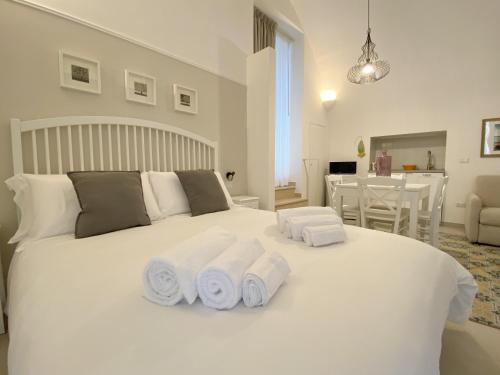 a bedroom with a white bed with towels on it at Domina Living Apartments - Montecucco in Bisceglie