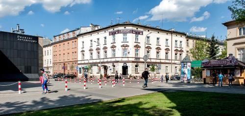 un grupo de personas caminando por una calle con conos de tráfico en Station Aparthotel, en Cracovia