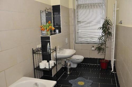 ein schwarzweißes Bad mit einem Waschbecken und einem WC in der Unterkunft Große Fewo Dresden Neustadt/Zentrum L9 in Dresden