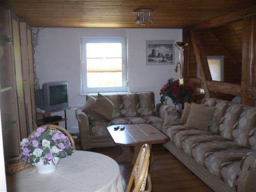 uma sala de estar com um sofá e uma mesa em Pension-Drews em Grubenhagen